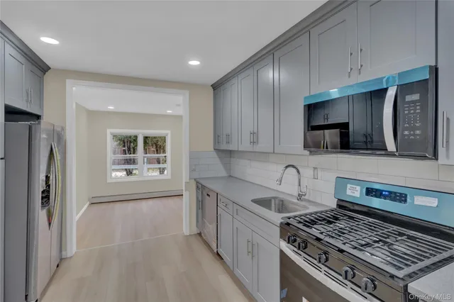 a kitchen with stainless steel appliances granite countertop a stove a sink and a microwave