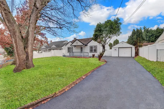 a view of a house with a yard and a large tree