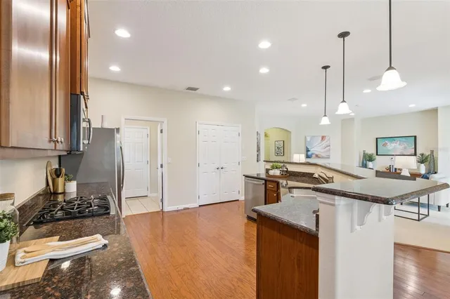 a kitchen with stainless steel appliances granite countertop a sink a stove and a refrigerator