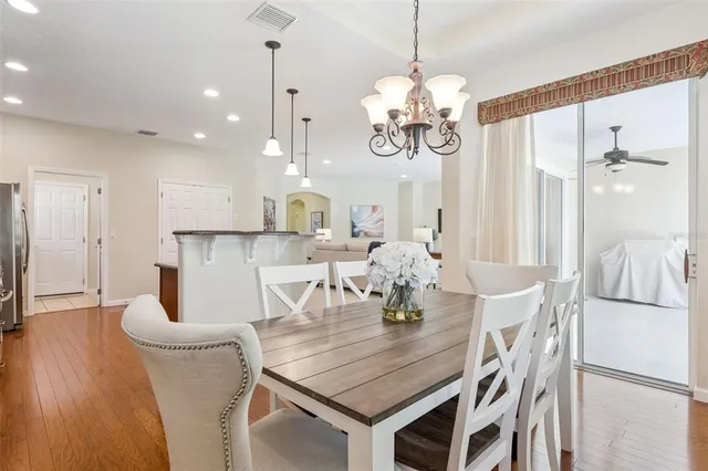 a dining room filled chandelier and wooden floor