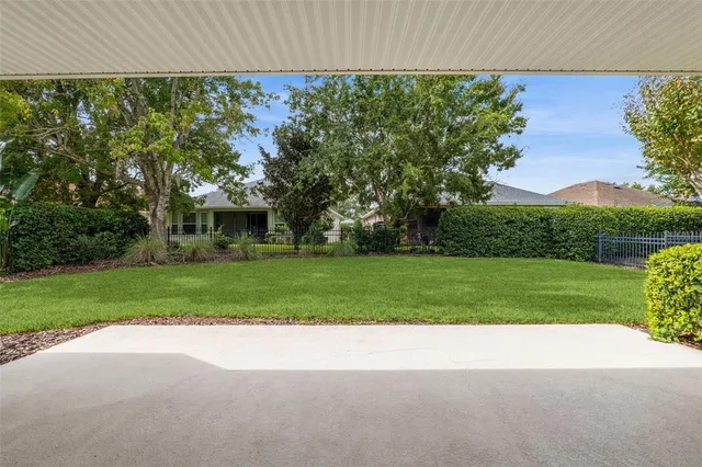 a view of a house with a big yard and large trees