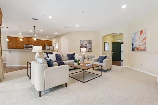 a living room with furniture and a view of kitchen