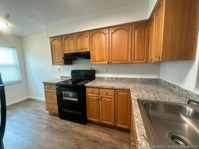 6022 Indrio Road, Unit G1 Fort Pierce, FL 34951 - Photo 6 of 23 a kitchen with stainless steel appliances granite countertop a stove a sink and a microwave