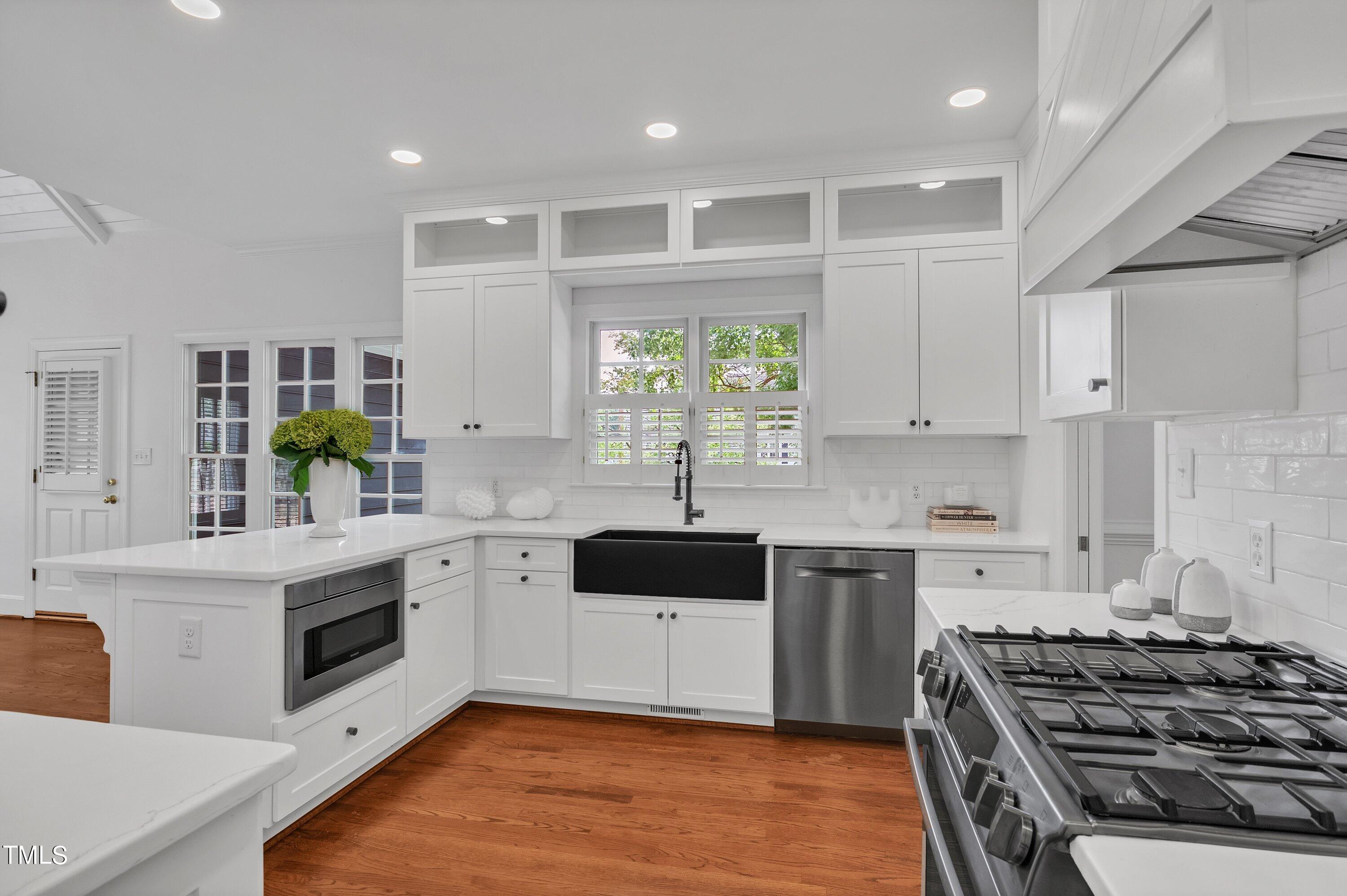 8500 Caldbeck Drive Raleigh, NC 27615 - Photo 16 of 37 a kitchen with a white stove top oven sink and cabinets