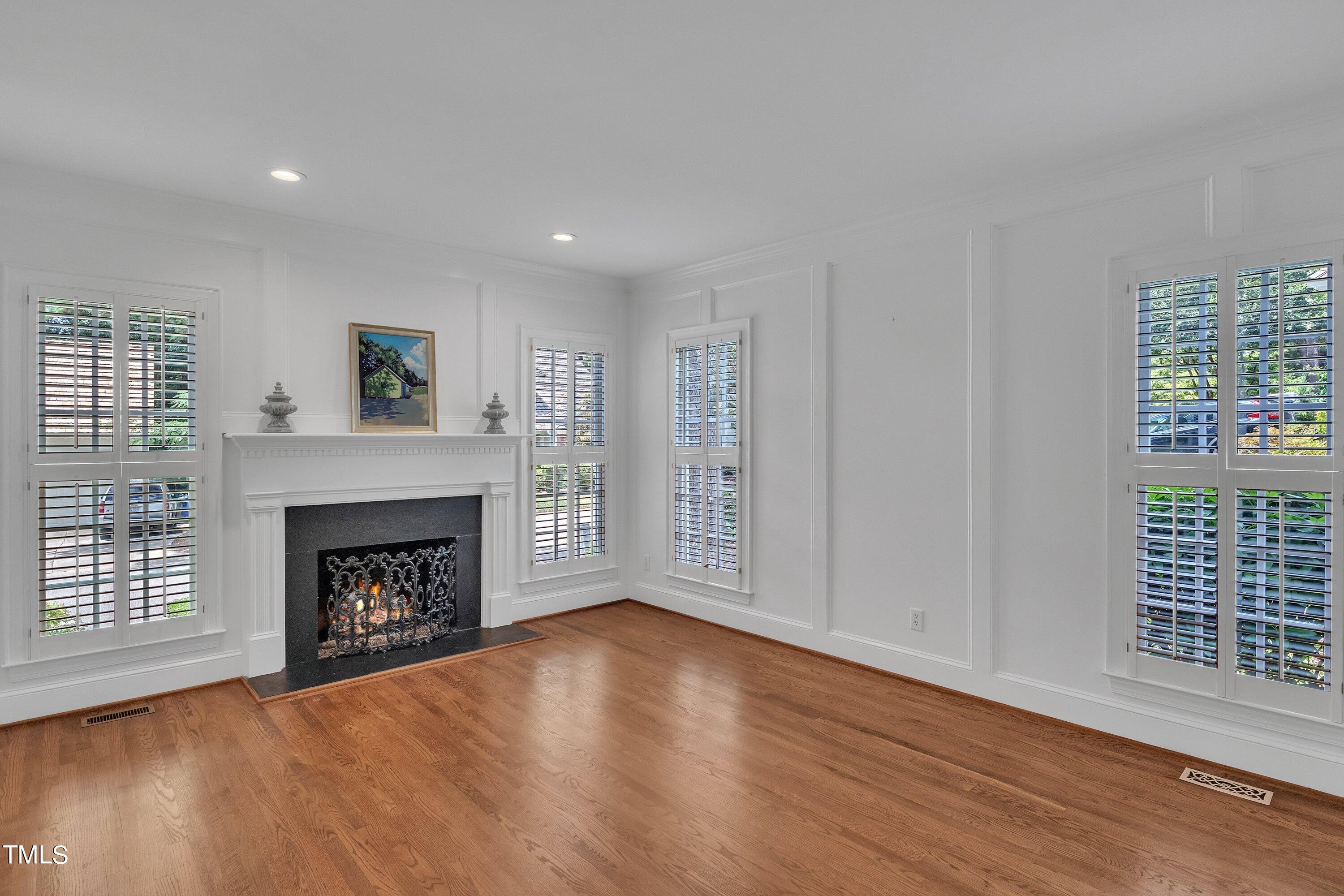 8500 Caldbeck Drive Raleigh, NC 27615 - Photo 8 of 37 a view of an empty room with wooden floor fireplace and a window