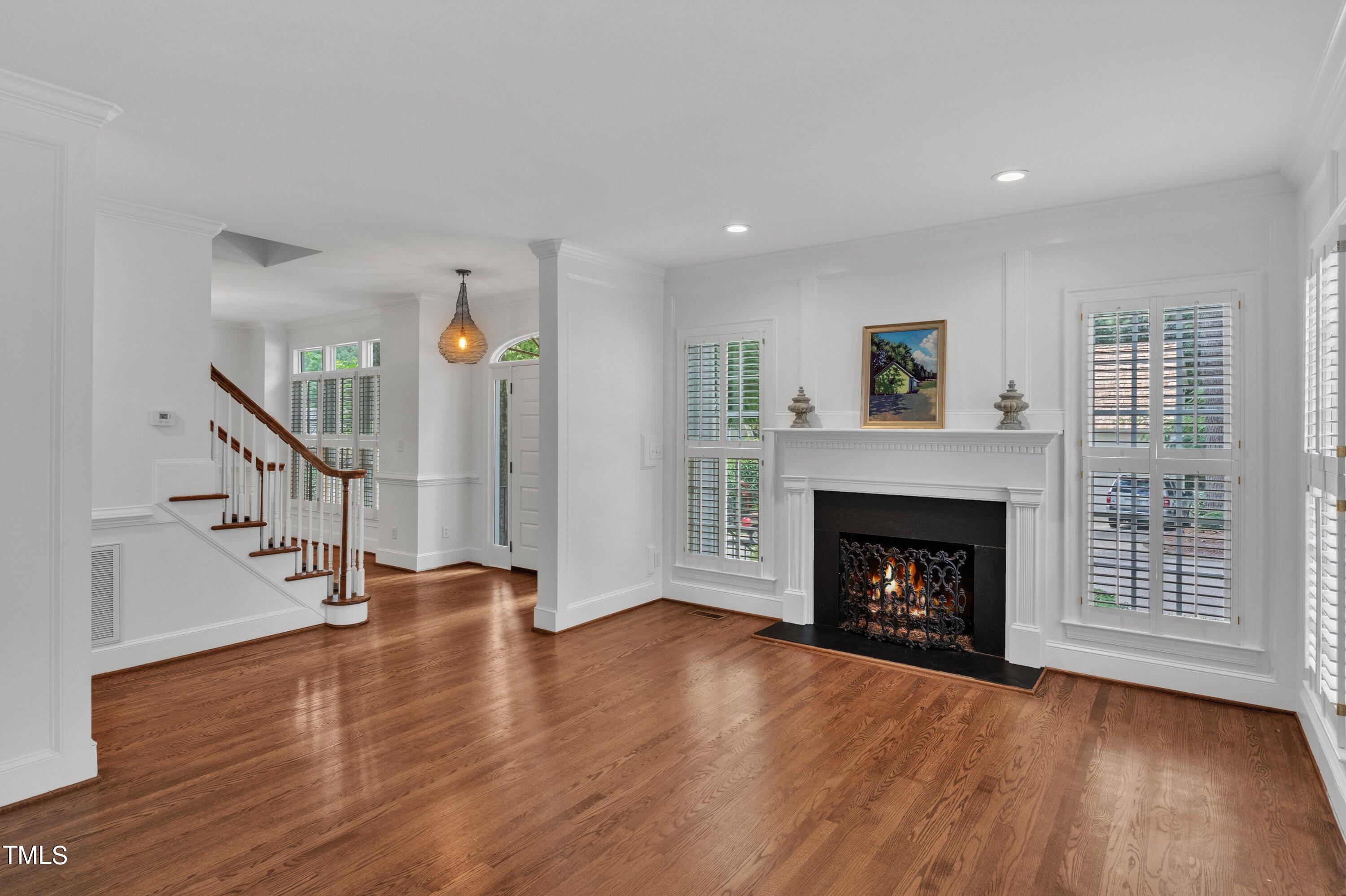 8500 Caldbeck Drive Raleigh, NC 27615 - Photo 9 of 37 a view of an empty room with wooden floor fireplace and a window