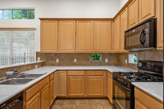 a kitchen with a sink stove top oven and cabinets