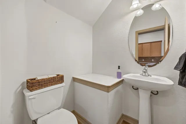a bathroom with a toilet a sink and mirror