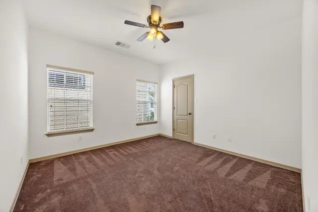 an empty room with closet and chandelier fan