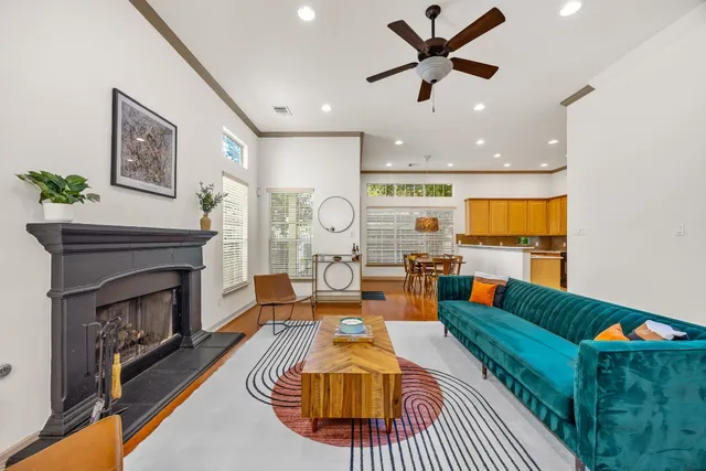 a living room with furniture a fireplace and a dining table with wooden floor