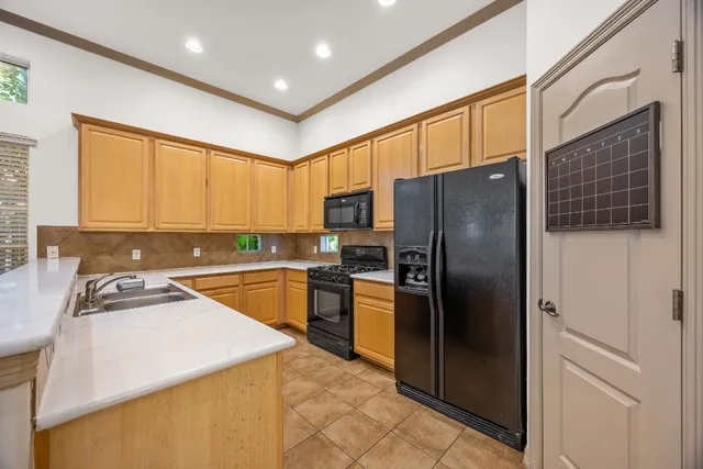 a kitchen with stainless steel appliances granite countertop a refrigerator a sink a stove and island