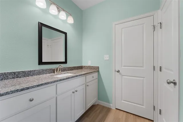 a bathroom with a granite countertop sink vanity and mirror