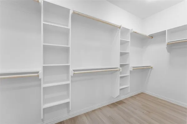 a view of walk in closet with empty racks