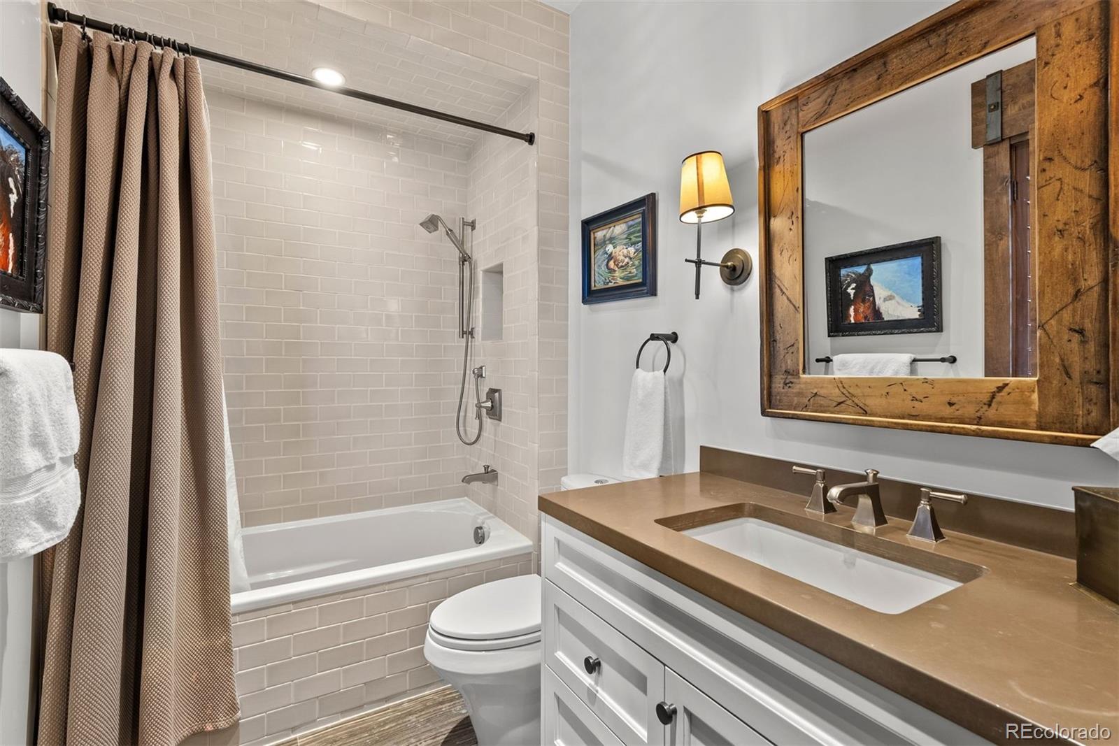 34650 Sleeping Fox Trail Evergreen, CO 80439 - Photo 25 of 49 a bathroom with a granite countertop sink toilet and shower a mirror