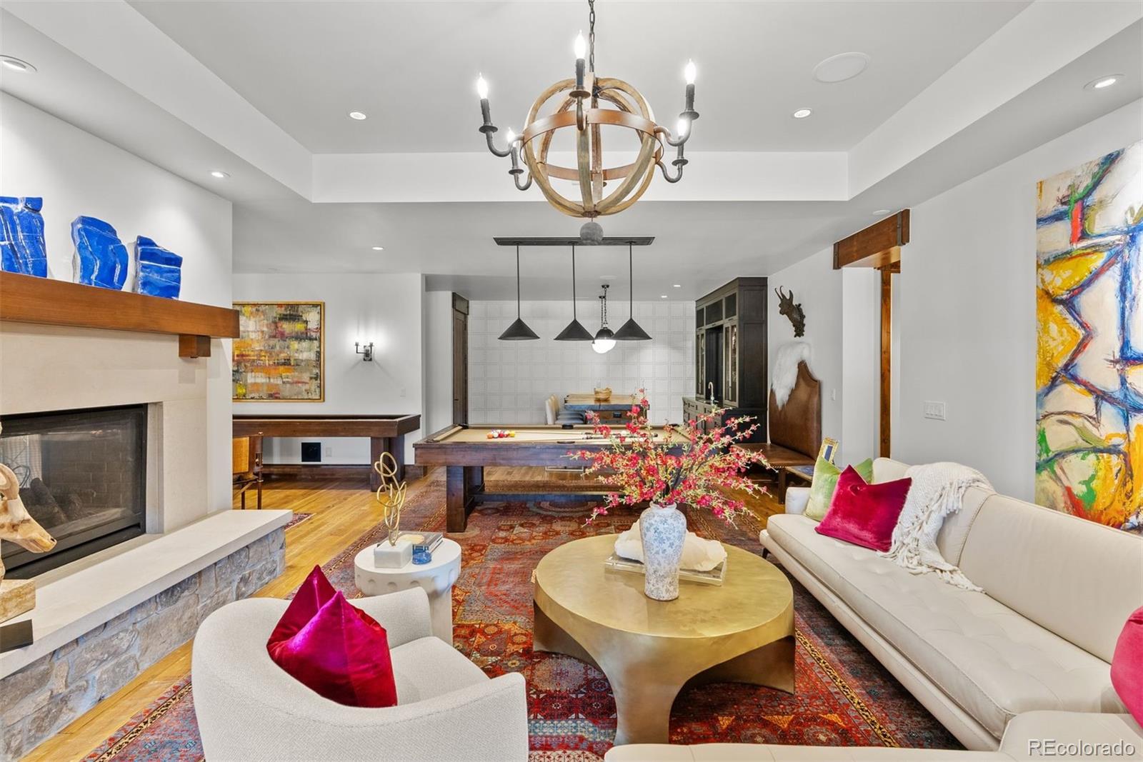 34650 Sleeping Fox Trail Evergreen, CO 80439 - Photo 27 of 49 a living room with furniture a chandelier and a fireplace