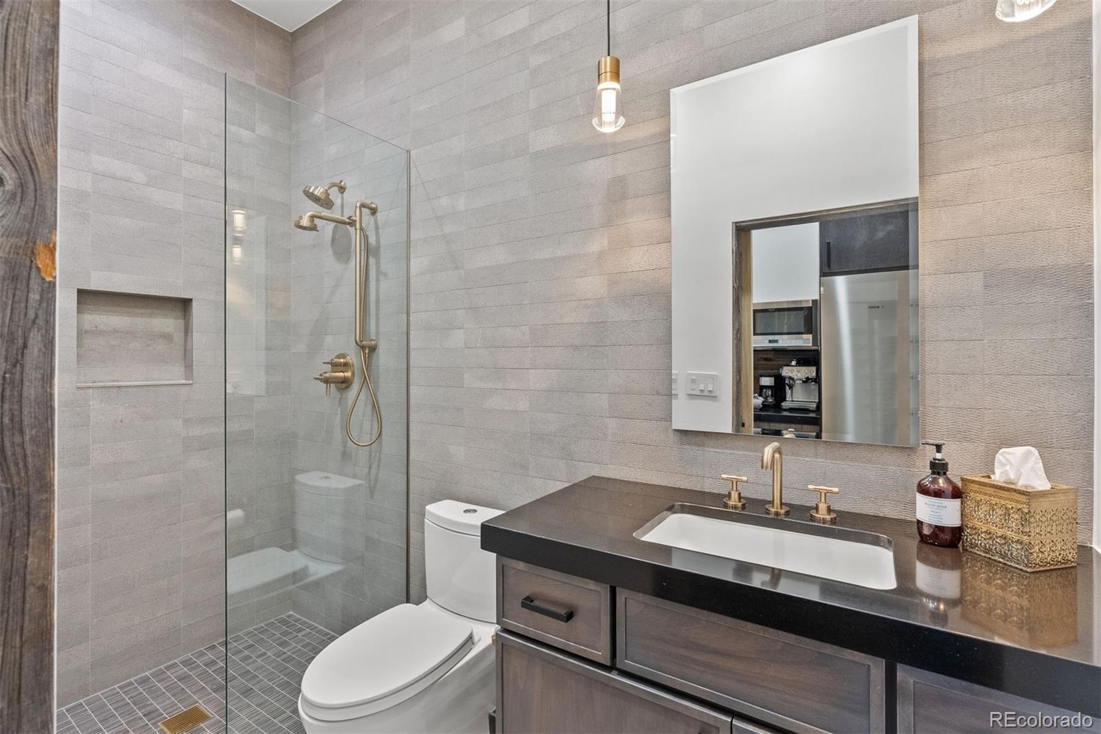 34650 Sleeping Fox Trail Evergreen, CO 80439 - Photo 47 of 49 a bathroom with a granite countertop sink toilet a mirror and shower