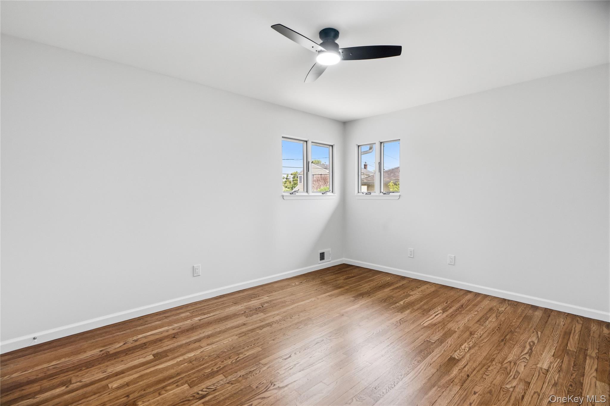 183 North Marginal Road Jericho, NY 11753 - Photo 15 of 28 Bright interior bedroom featuring wood-finish flooring, white baseboards, and white walls