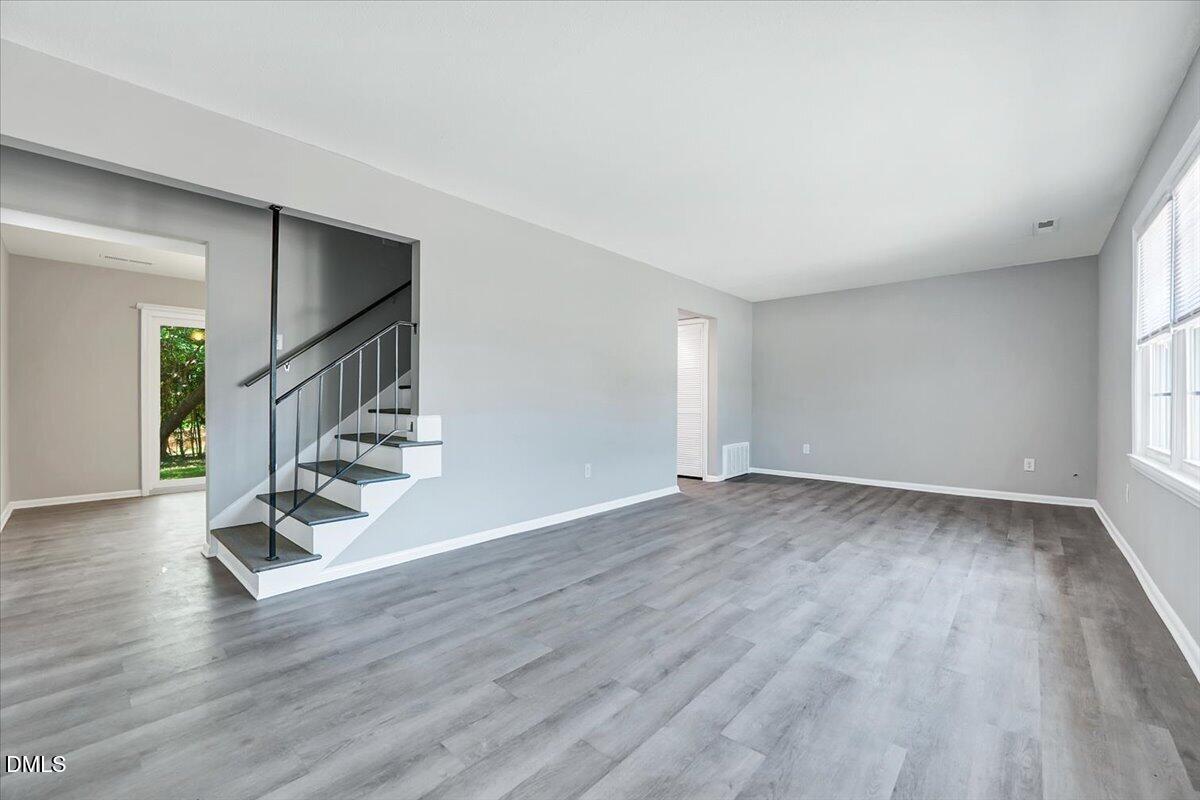 3408 Atlantic Avenue Raleigh, NC 27604 - Photo 24 of 48 a view of an empty room with wooden floor and stairs