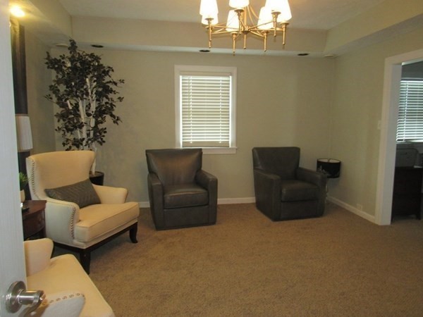 a living room with furniture and a chandelier