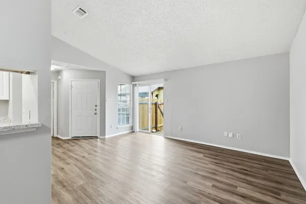 a view of a room with wooden floor and entryway