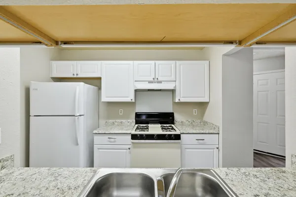a kitchen with a refrigerator and a stove top oven