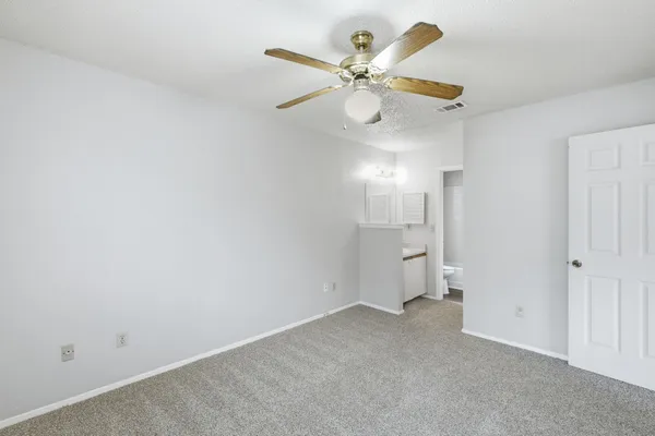 an empty room and chandelier fan