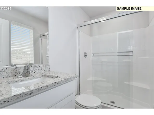 a bathroom with a granite countertop sink mirror and shower