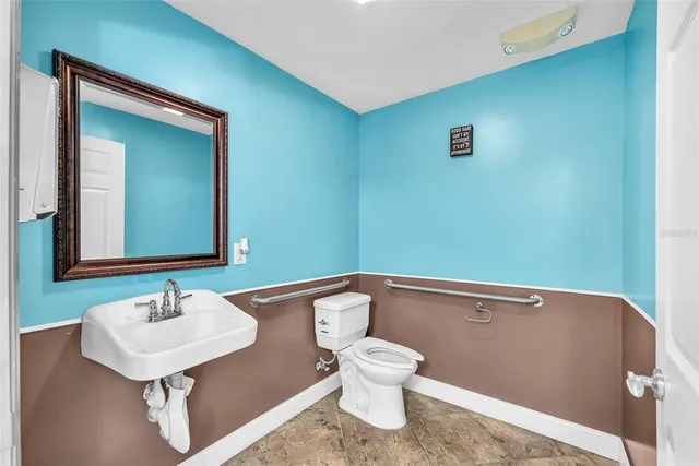 a bathroom with a sink a toilet and mirror