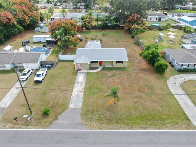an aerial view of a house with a yard and lake view