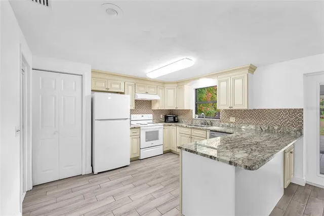 a kitchen with kitchen island granite countertop appliances cabinets and a counter space