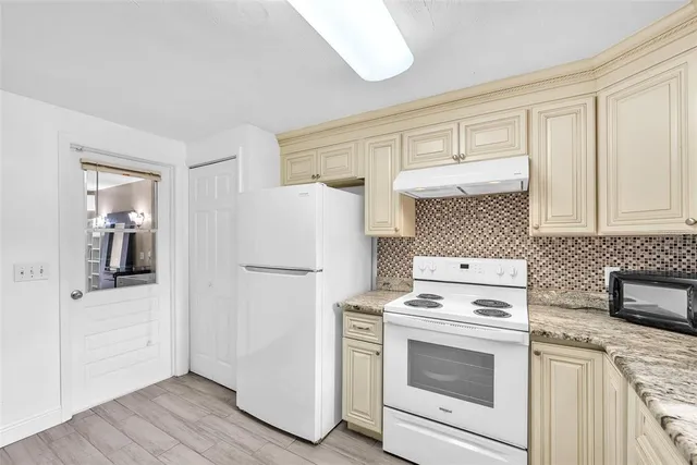 a kitchen with white cabinets and white appliances