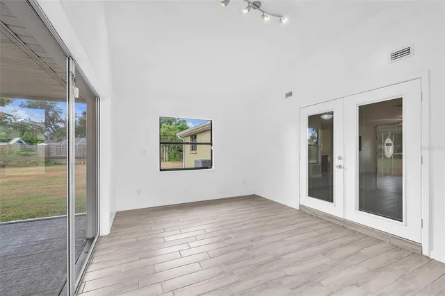 an empty room with wooden floor and windows
