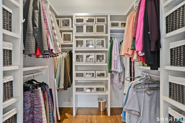 a view of walk in closet with clothes and shoes