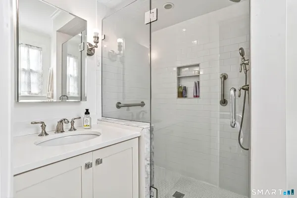 a bathroom with a shower sink and mirror