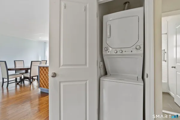 a view of a hallway with wooden floor washer and dryer