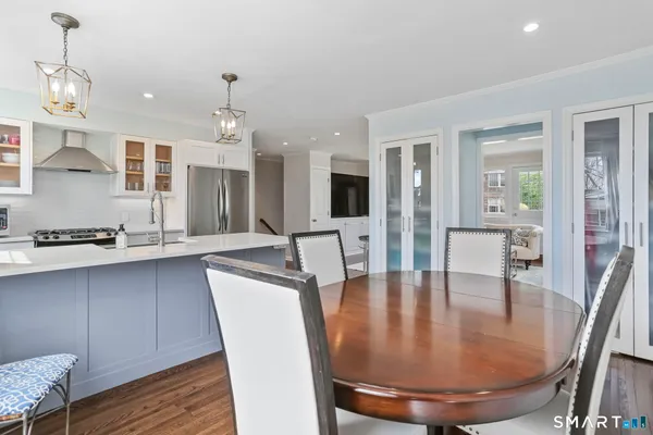 a dining room with wooden floor and chandelier