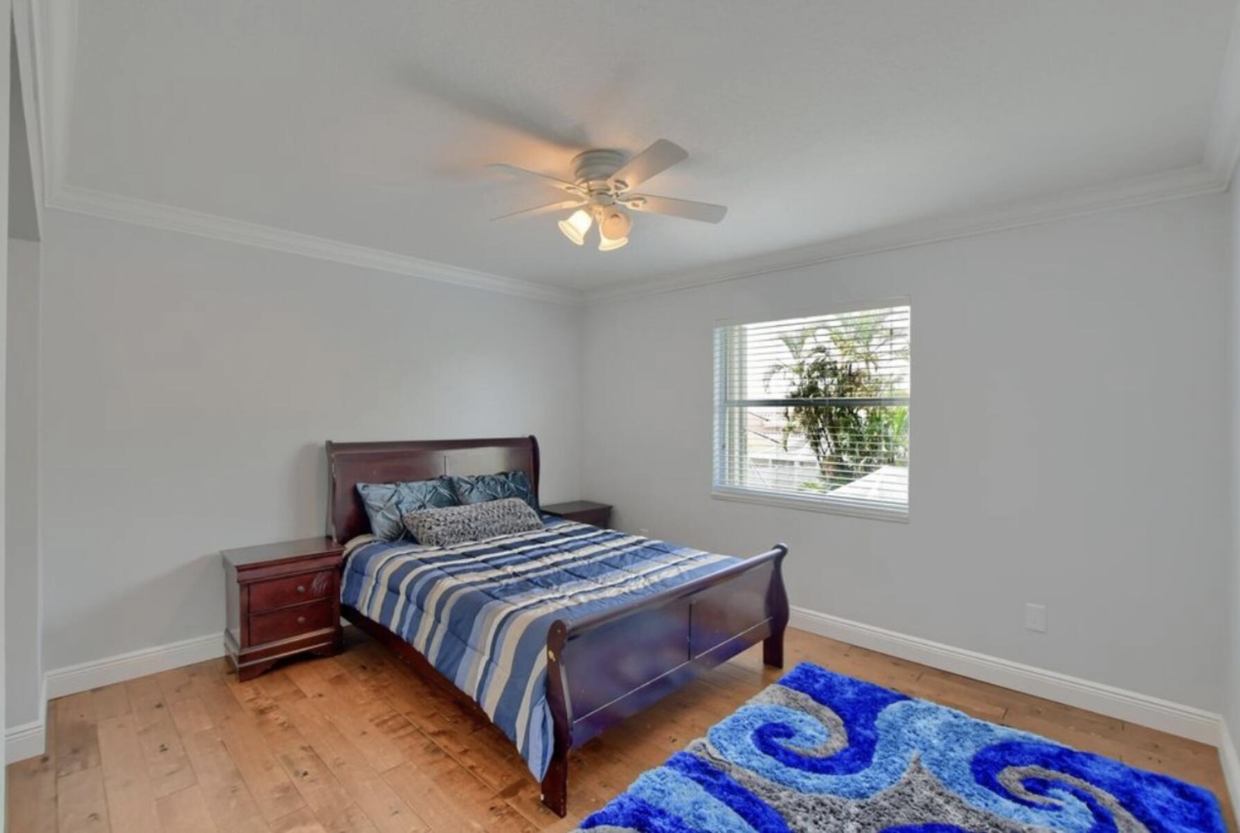 9460 Lake Serena Drive Boca Raton, FL 33496 - Photo 12 of 21 a bedroom with a bed and a lamp on the dresser