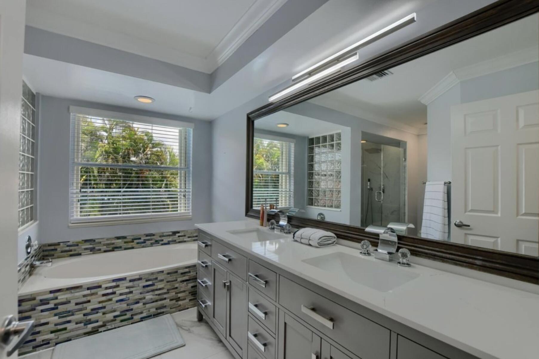 9460 Lake Serena Drive Boca Raton, FL 33496 - Photo 20 of 21 a bathroom with a tub a sink and a large mirror