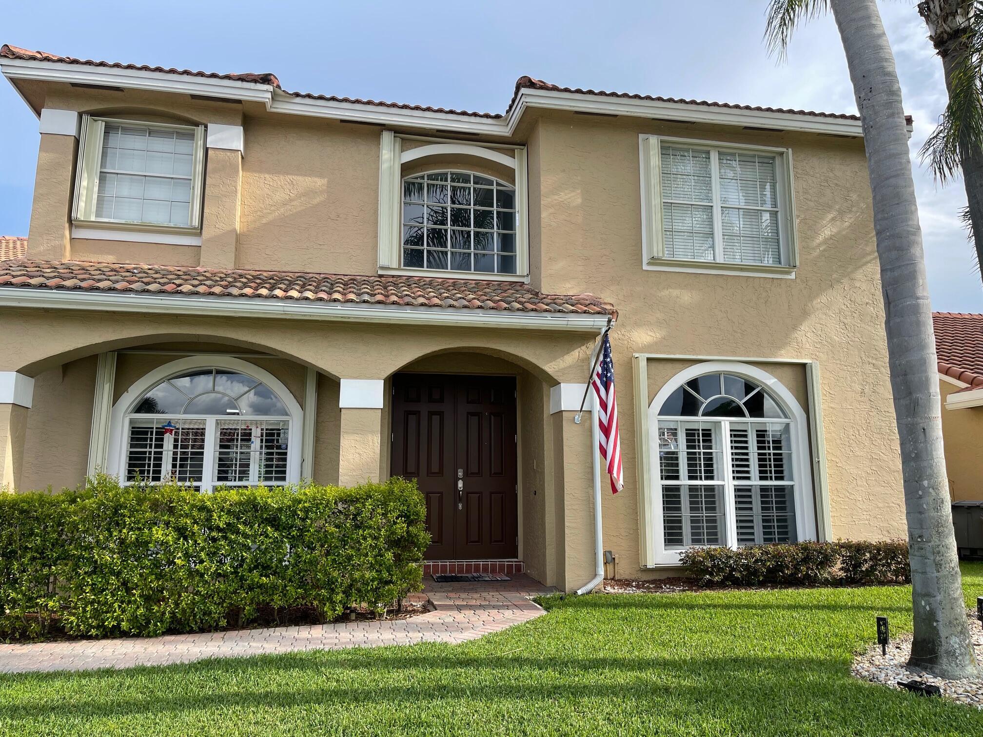9460 Lake Serena Drive Boca Raton, FL 33496 - Photo 2 of 21 a front view of a house with garden