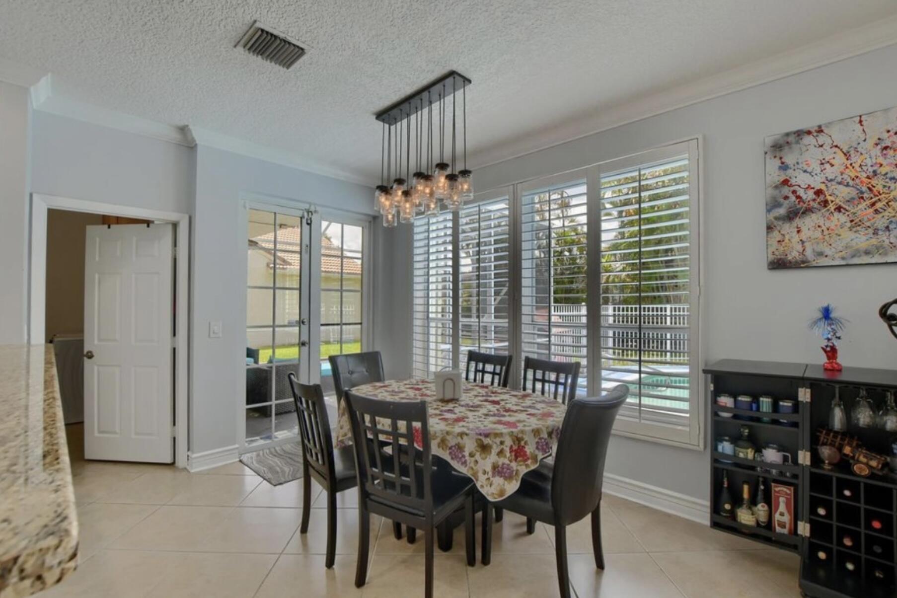 9460 Lake Serena Drive Boca Raton, FL 33496 - Photo 8 of 21 a view of a dining room with furniture window and outside view
