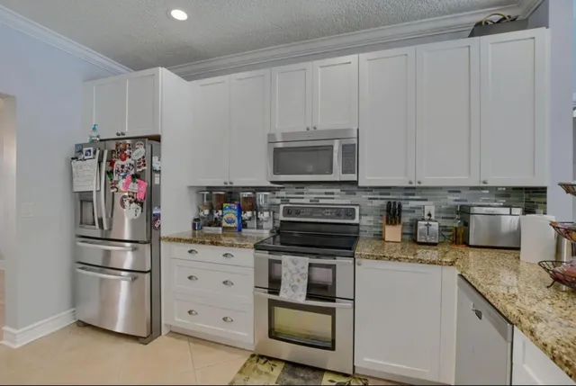 a kitchen with stainless steel appliances granite countertop a refrigerator sink and cabinets