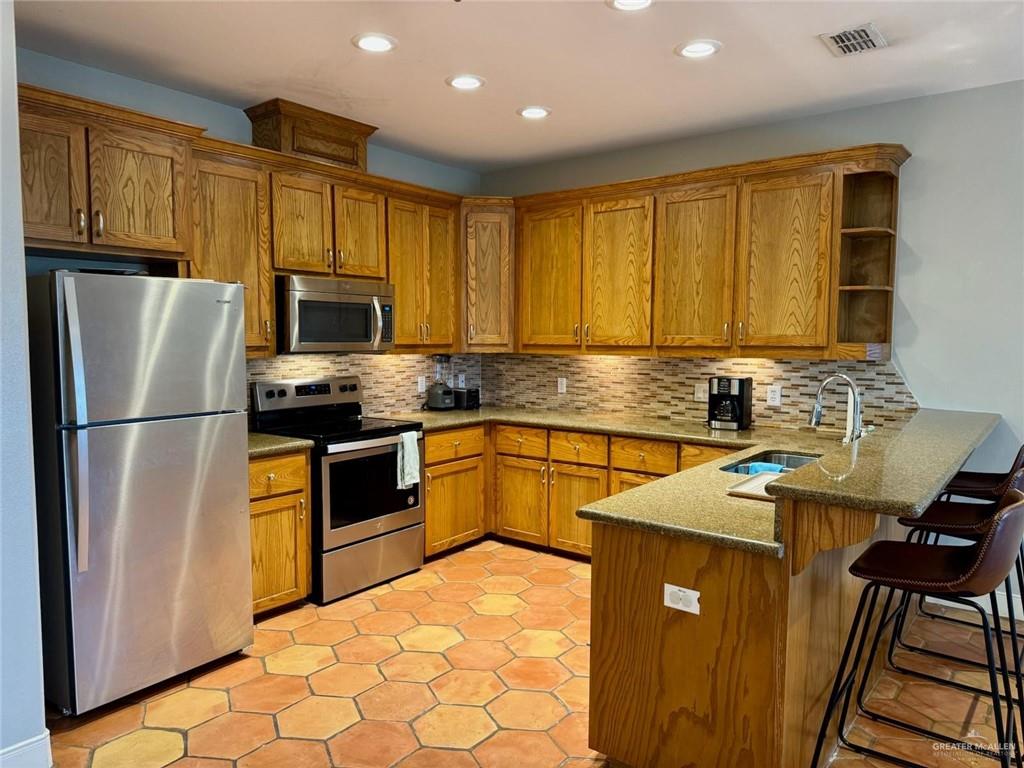 1412 Keeton Avenue, Unit 28 McAllen, TX 78503 - Photo 5 of 15 a kitchen with granite countertop a refrigerator a stove top oven cabinets and a sink