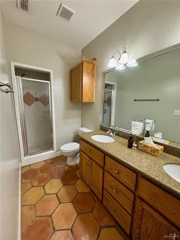 a spacious bathroom with a granite countertop sink toilet and mirror