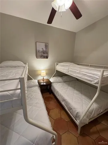 a bedroom with a bed and a ceiling fan