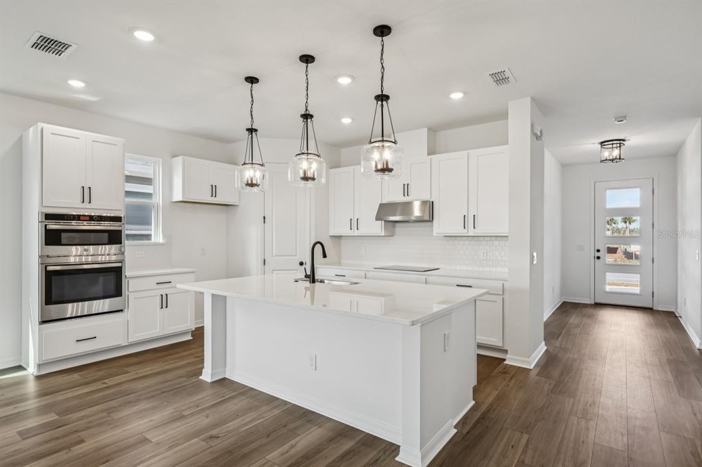 6644 Wake Street St. Cloud, FL 34771 - Photo 13 of 48 a large kitchen with cabinets and wooden floor