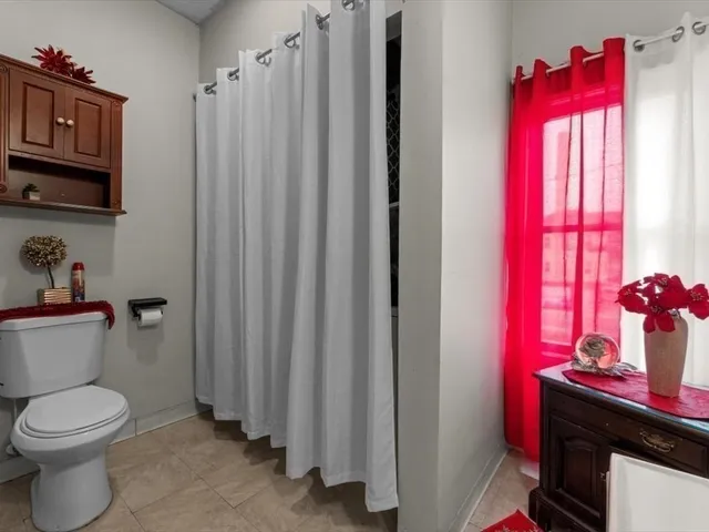 a bathroom with a toilet a sink and a window