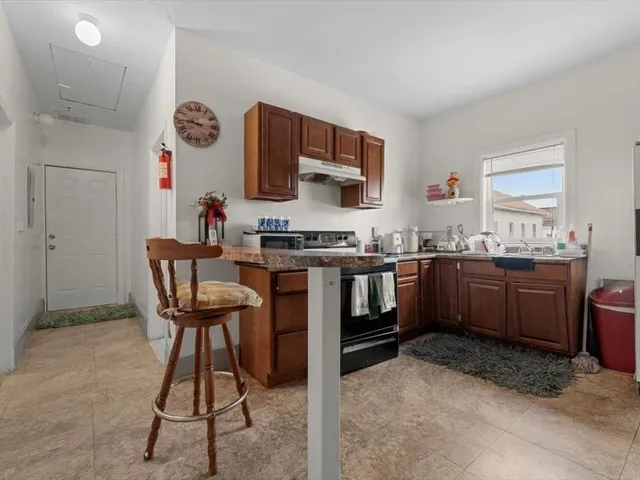 a kitchen with stainless steel appliances a stove a sink cabinets and a refrigerator