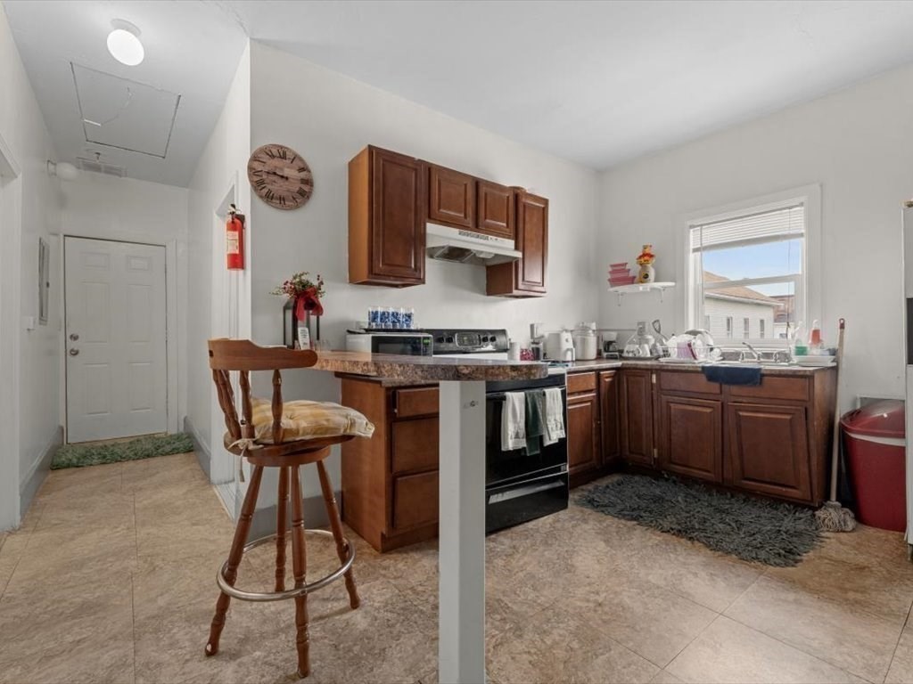 120 Grand Street Worcester, MA 01603 - Photo 17 of 36 a kitchen with stainless steel appliances a stove a sink cabinets and a refrigerator