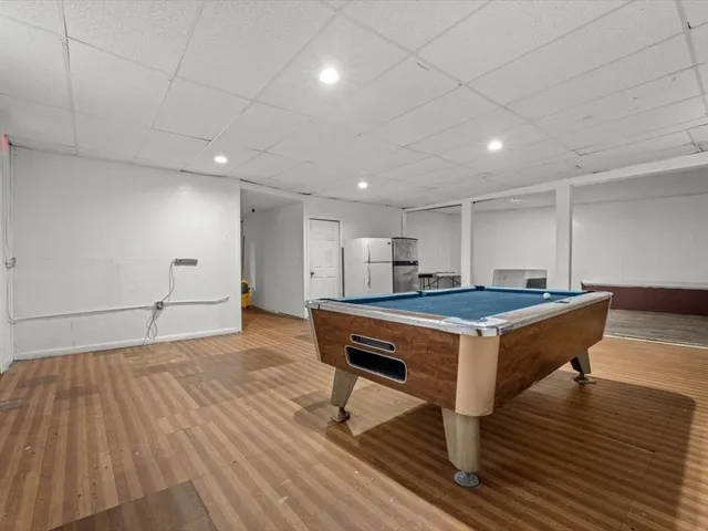 a room with wooden floor and pool table