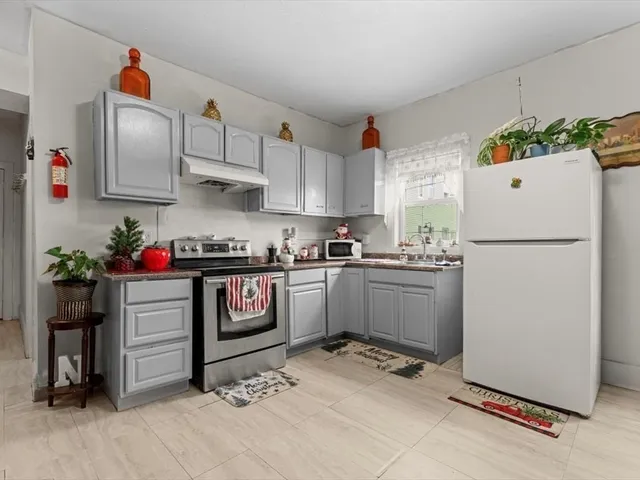 a kitchen with a refrigerator and white cabinets